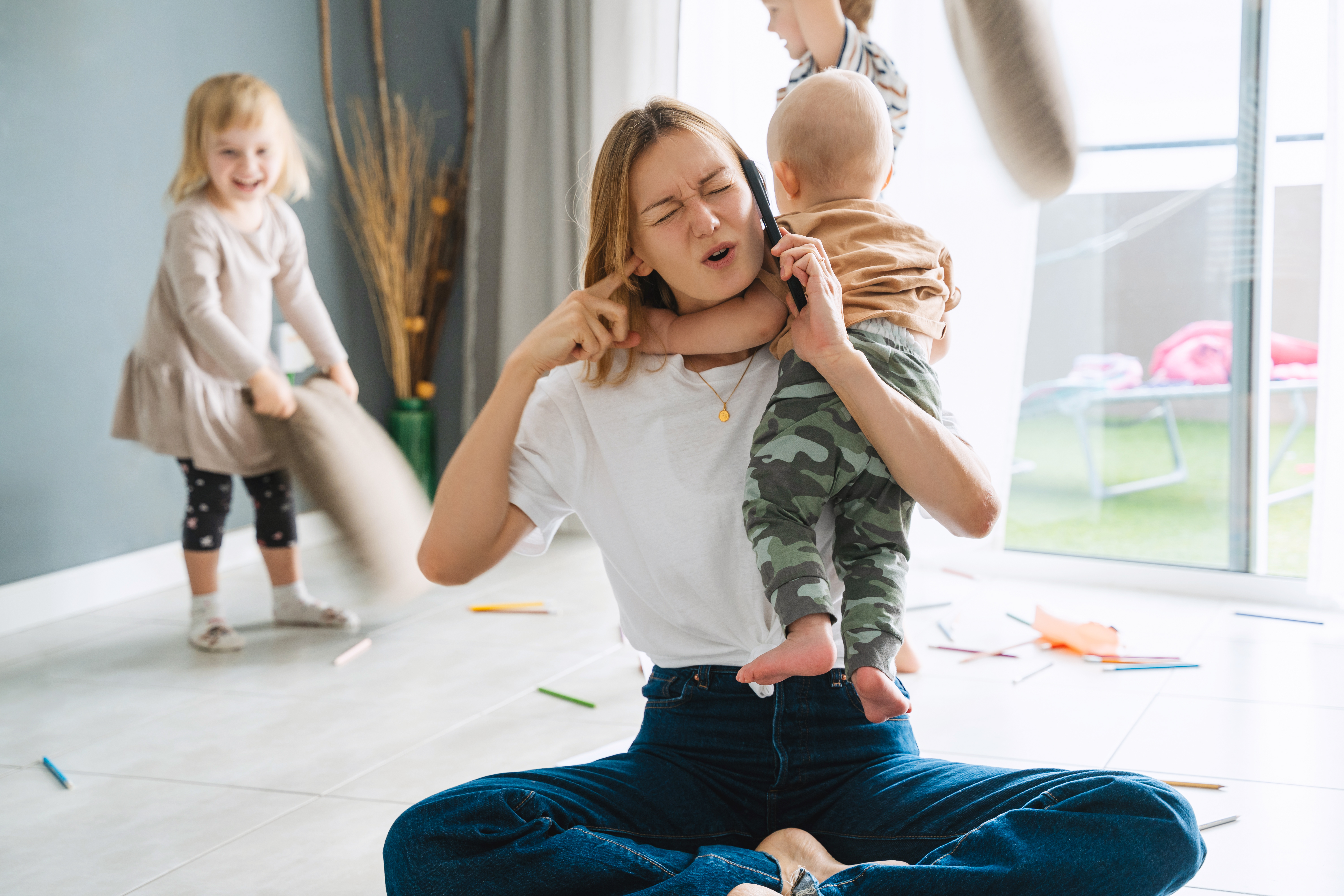woman-alone-with-three-children-home-solving-problems-using-phone-mother-holding-baby-her-arms-trying-talking-phone-call-while-older-children-are-playing-distracting-her-nearby-room